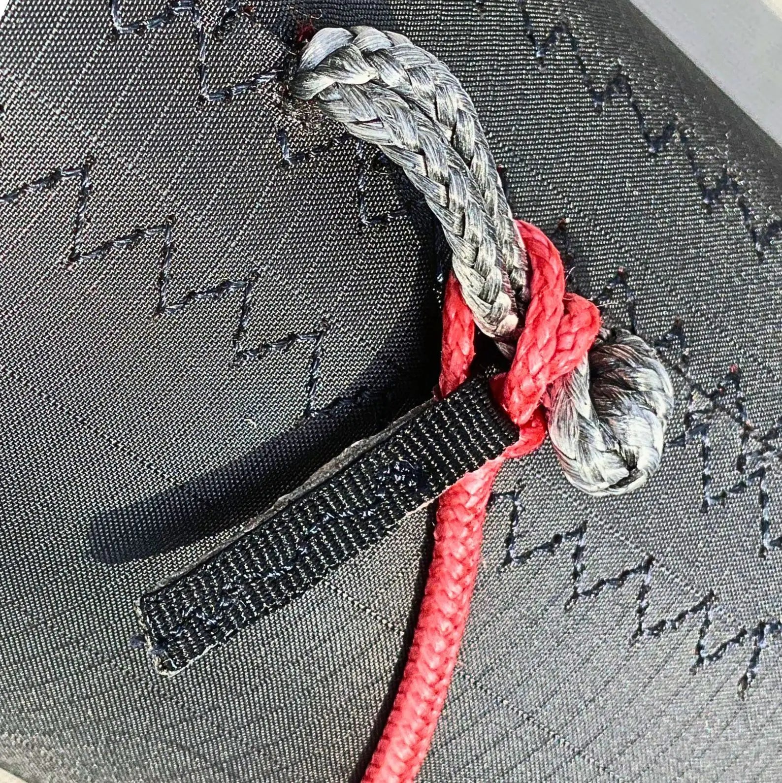 Detail shot of the Sebba Shade marine canopy, showing a low-stretch Dyneema cord locked into one of the 16 available airframe pigtails, demonstrating how users can choose their connection points for multi-directional adjustability.