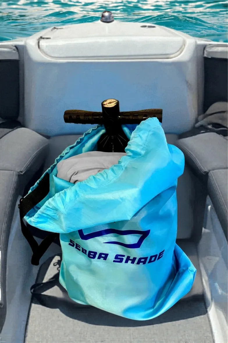 The Sebba Shade stowed in its rugged, marine-grade duffel bag on a boat deck, highlighting its compact 12 lb storage footprint.