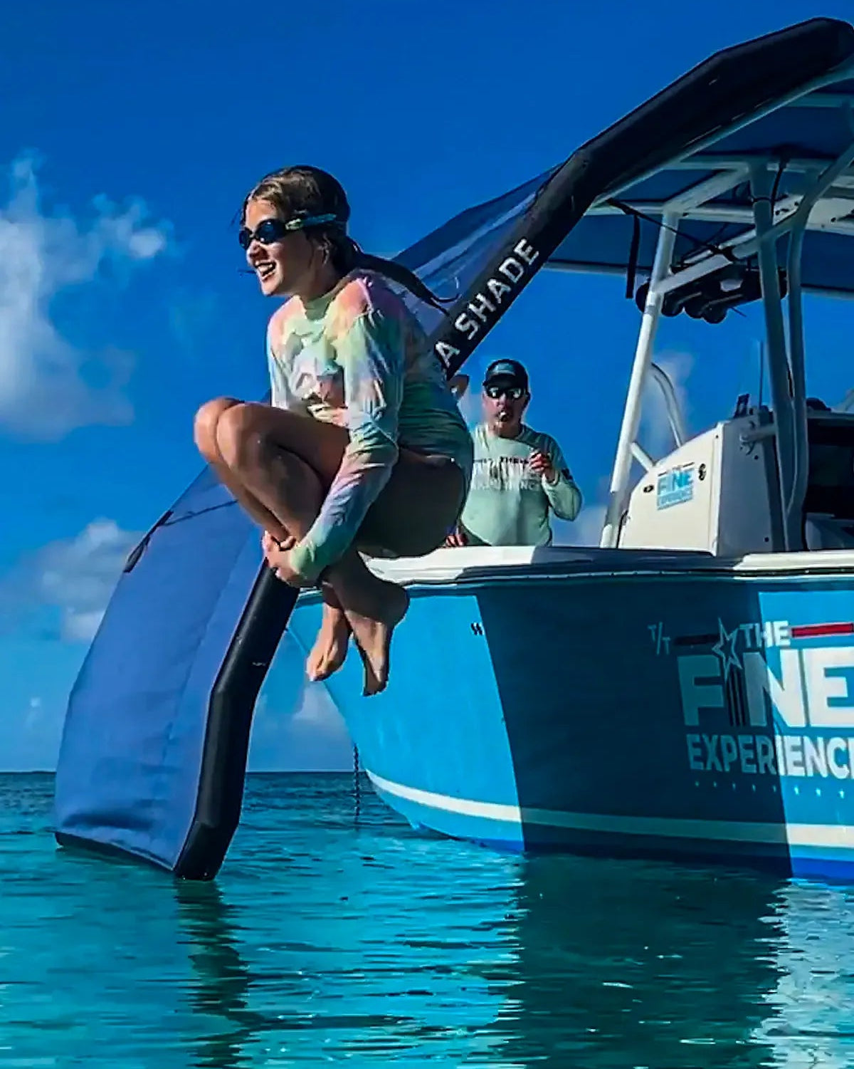 Vertical view of the Sebba Shade extending over the side of the boat, floating on the water to create a protected area for swimming underneath.