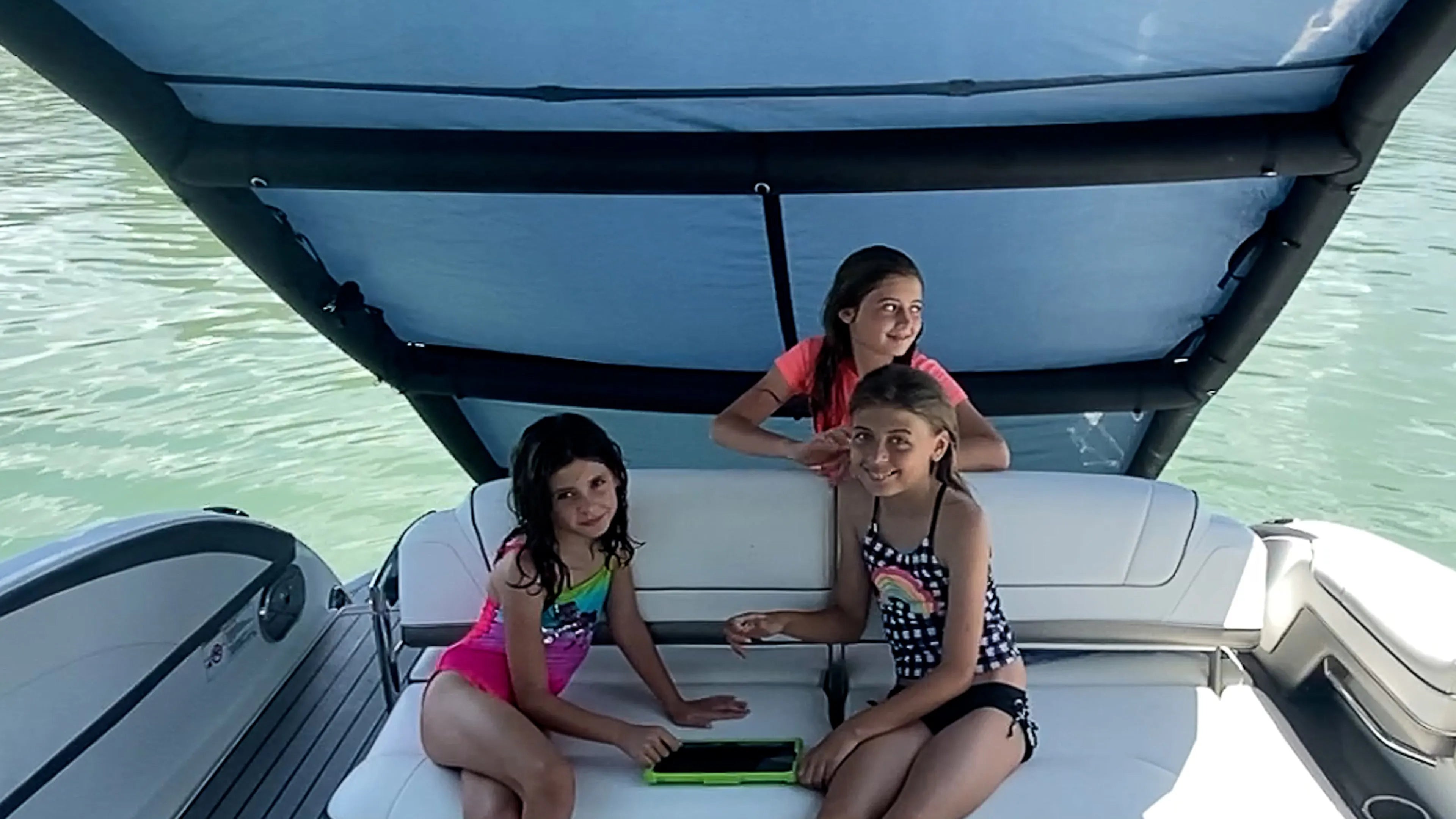 The same three children relaxing happily under the Sebba Shade canopy. This demonstrates how our multidirectional marine airframe easily repositions to block the moving sun, providing continuous cooling and UV protection.
