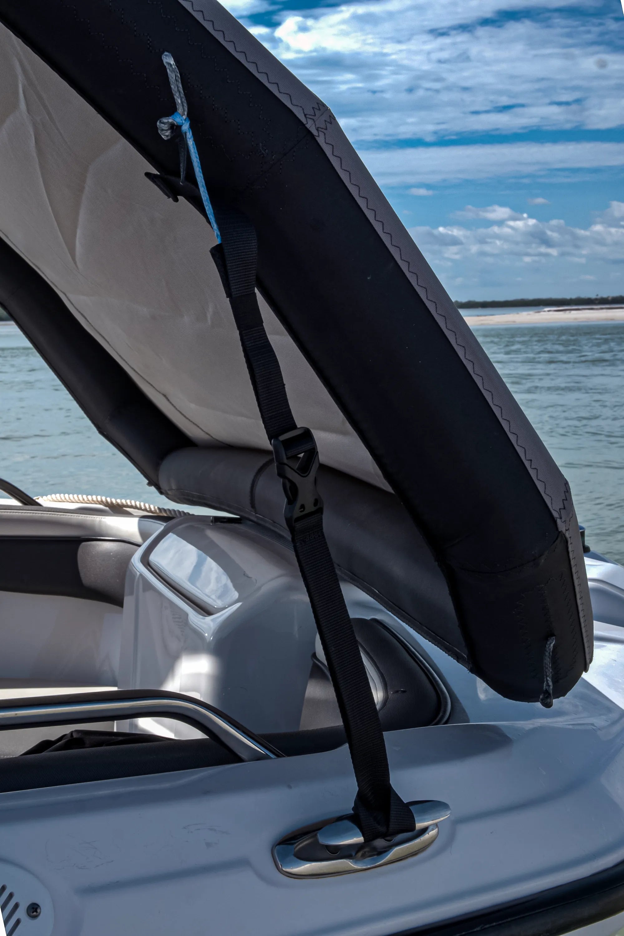 Detail of the Sebba Shade 2ft rigging strap showing the blue Dyneema® cord fastened to an airframe pigtail and the polyester strap secured directly to a boat cleat for a no-drill installation.