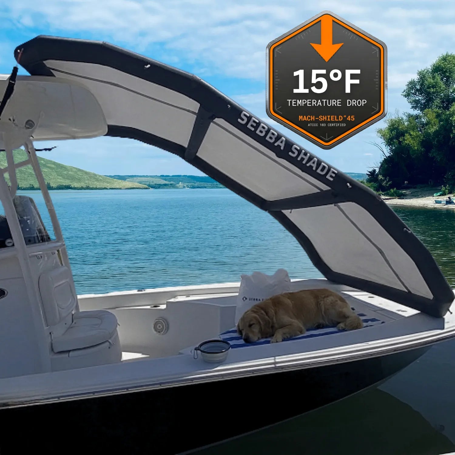 A dog sleeping comfortably in the deep shade on the bow of a boat under a Sebba Shade canopy. A graphic overlay indicates a 15-degree Fahrenheit temperature drop, demonstrating the thermal cooling performance and UV protection of the Mach-Shield 45 textile.