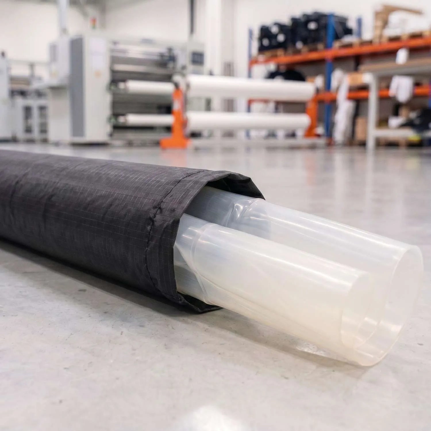 A technical cross-section photograph of the Sebba Shade dual-layer airframe system. The image reveals the internal polyether-based TPU bladder emerging from the high-tenacity 150x250 weave AeroCasing™ exoskeleton, demonstrating the structural engineering between the internal pressure engine and the protective outer shell.